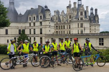 Le groupe de cyclistes en tandem voyant et non-voyants posent devant le château de Chambord