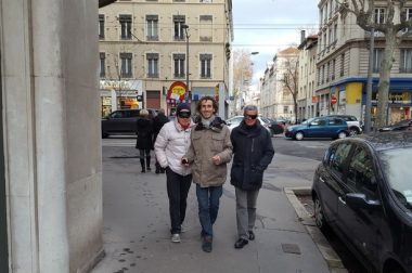 Pierre Duvinage et desbénvoles avec bandeua dans les rues de Lyon
